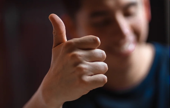 un homme souriant lève son pouce